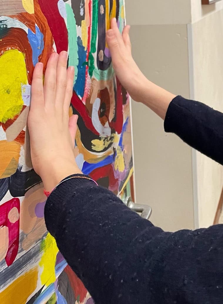 le mani di una donna toccano un'opera d'arte realizzata su una porta