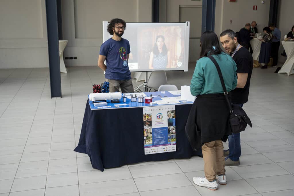 Inside the San Gaetano Cultural Center, two professors explain to a woman their science popularization project with tactile models "Stars on Earth"