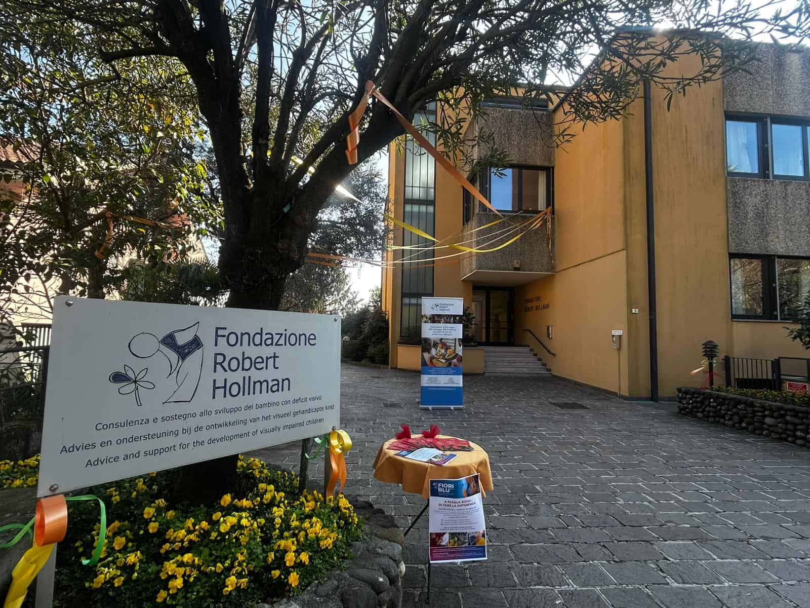 Facciata della Fondazione Robert Hollman con segnaletica e decorazioni.